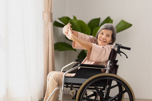 elderly asian woman doing stretching exercise on wheelchair in l